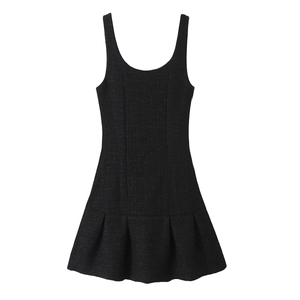 Detail showing the textured fabric and ruffled A-line hem of the black mini dress