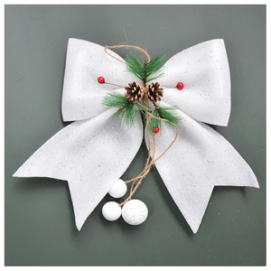 Detailed view of white glitter Christmas bow with pine cones and red berries on ribbon