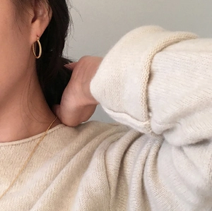 Chic 925 sterling silver golden twisted rope hoop earrings worn by a model in a cozy style