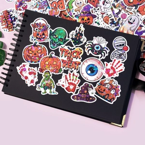 Macro detail of holographic Halloween stickers on black notebook with laser-like shine