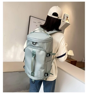 Detail view of mint green high-density nylon travel backpack with brand logo and buckles