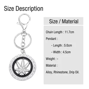 Silver maple leaf keychain with white rhinestones and black enamel detail on white background