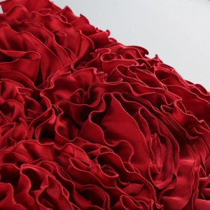 Détail de tissu satiné rouge à volants avec ourlet haute densité et fini soyeux