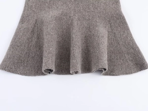 Detail view of dark grey knitted skirt hem featuring a ruffled wavy cut and thick fabric