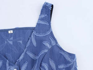 Détail du col d'une robe en denim bleu avec étiquette taille S et textures effilochées