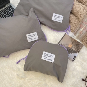 Detailed set of three grey waterproof storage bags with purple zippers for travel organization