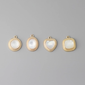 Detail of 18k gold plated oval and heart natural shell pendants for DIY jewelry making
