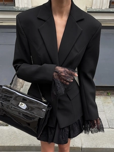 Detail of lace patchwork on cuffs of a slim fit black blazer for women in street style