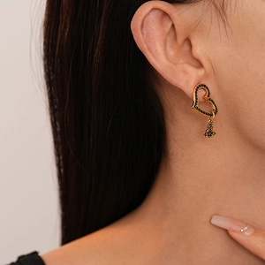 Vintage heart and planet earrings with black crystals and golden finish on female ear