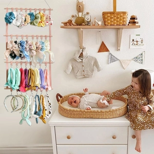 Wall-mounted PU leather hair accessory organizer with pink straps in a nursery room decor