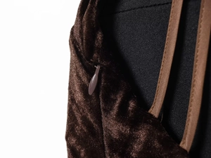 Close-up of invisible zipper and embossed dark brown velvet fabric on a dress