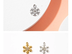 Detailed view of silver and gold snowflake charms with sparkling central rhinestones