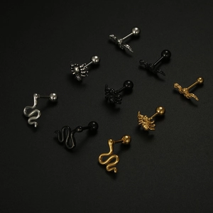 Macro detail of titanium spider and snake cartilage studs in silver, gold and black