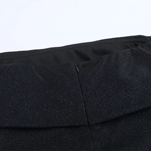 Close-up of sparkling black fabric and invisible zipper detail on the slit dress