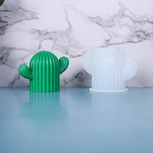 Detail view of cactus shaped silicone mold alongside the finished green handmade candle