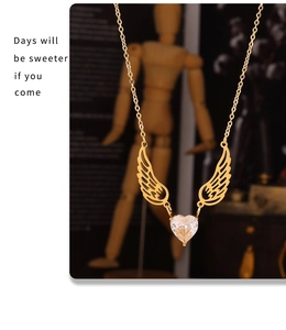 Macro detail of gold angel wing necklace with sparkling heart-shaped cubic zirconia