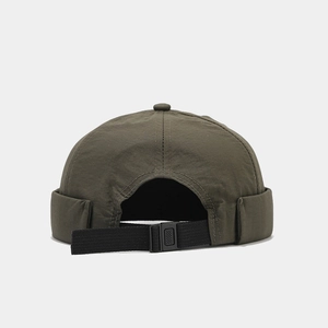 Detail of adjustable quick-release buckle and nylon fabric on olive green docker hat