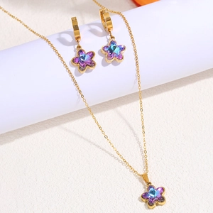 Detailed close-up of a gold floral jewelry set featuring gradient blue crystal petals