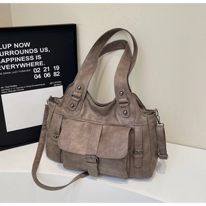 Detail of taupe soft leather tote with flap buckle pocket and dark gunmetal hardware