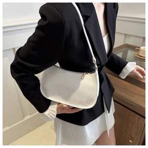 Detail of white crescent shoulder bag featuring smooth finish and gold metal hardware