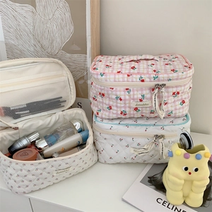 Detail view of large quilted cotton cosmetic bags with cherry patterns and mesh pockets