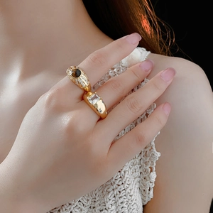 Detail von Vintage-Goldringen mit braunem Tigerauge und Zirkonia am Finger eines Modells