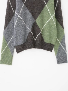 Détail du motif à losanges sur tricot avec ourlet côtelé et texture douce en mohair