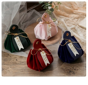 Detail of luxury velvet and leather wedding gift bags with pearl charms and metal buckles