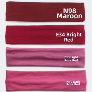 Detail of four red sports headbands in scarlet, crimson, and rose shades with soft texture