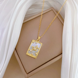 Detailed shot of The World tarot pendant with pearl and mother of pearl on gold chain