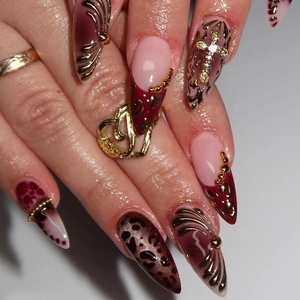 Macro shot of long stiletto nails with leopard print and 3D metal cross charms