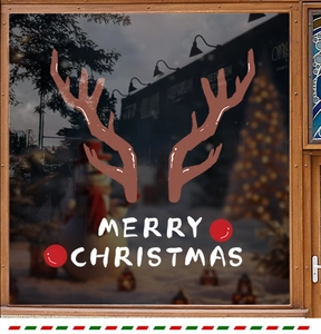 Close-up of reindeer antlers and Merry Christmas static cling stickers on a glass window