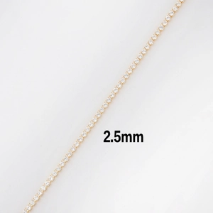 Macro detail of a 2.5mm gold-plated tennis chain featuring sparkling round-cut zircons