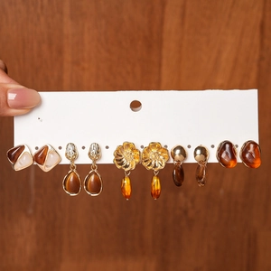 Close-up of a 6-pair set of amber resin earrings in vintage gold and floral designs