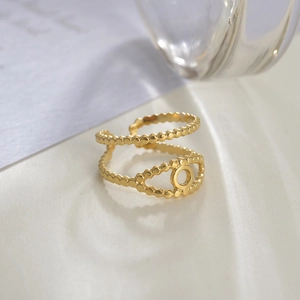 Detail of 14K gold double-layered beaded ring with unique circular cutout ornament