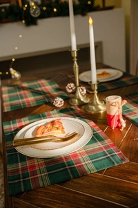 Close-up of red and green plaid table runner with festive Christmas dining decorations