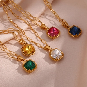 Macro detail of paperclip chain necklaces with multi-colored square gemstone pendants