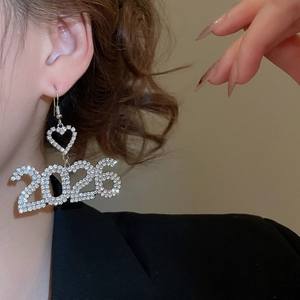 Dettaglio orecchini color argento con strass lucenti numero 2026 e a forma di cuore