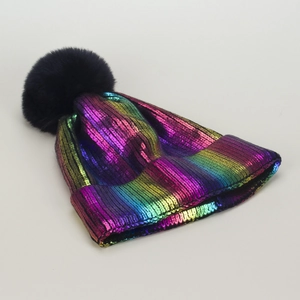 Dettaglio del cappello in maglia metallizzata arcobaleno con pompon in ecopelliccia