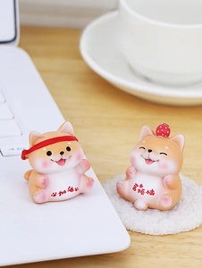 Close-up of cute shiba inu resin figurines with strawberry and headband desk decor
