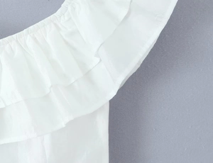 Detail of white off-the-shoulder top featuring multi-layered ruffled fabric and soft texture
