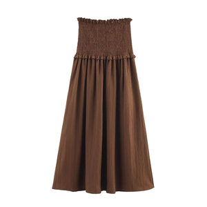 Detailed view of dark brown smocked high waist skirt with delicate ruffle trim and texture