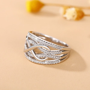Macro shot of a wide silver-toned ring with multi-layer interlaced lines and pavé zircons