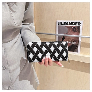 Close-up of a long wallet featuring black and white woven pattern and gold zipper detail