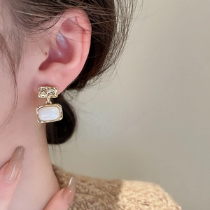 Close-up of vintage resin square stud earrings with gold plating on female model