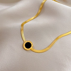 Macro shot of gold Roman numeral pendant necklace on silk backdrop detail