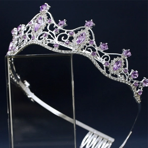 Detailed close-up of silver bridal crown with purple rhinestones on a display stand