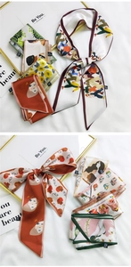 Close-up of assorted French style long silk scarves with artistic floral and face prints
