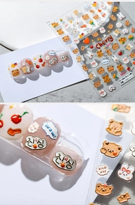 Macro detail of 3D embossed cartoon bear nail stickers with cherry and rabbit motifs