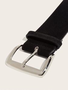 Detail view of a black suede waist belt featuring a polished silver square metal buckle